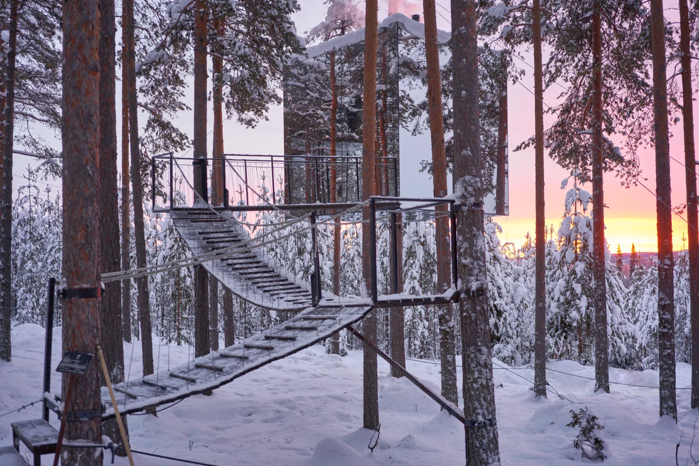 The Mirrorcube at Treehotel among snow-covered trees in Harads